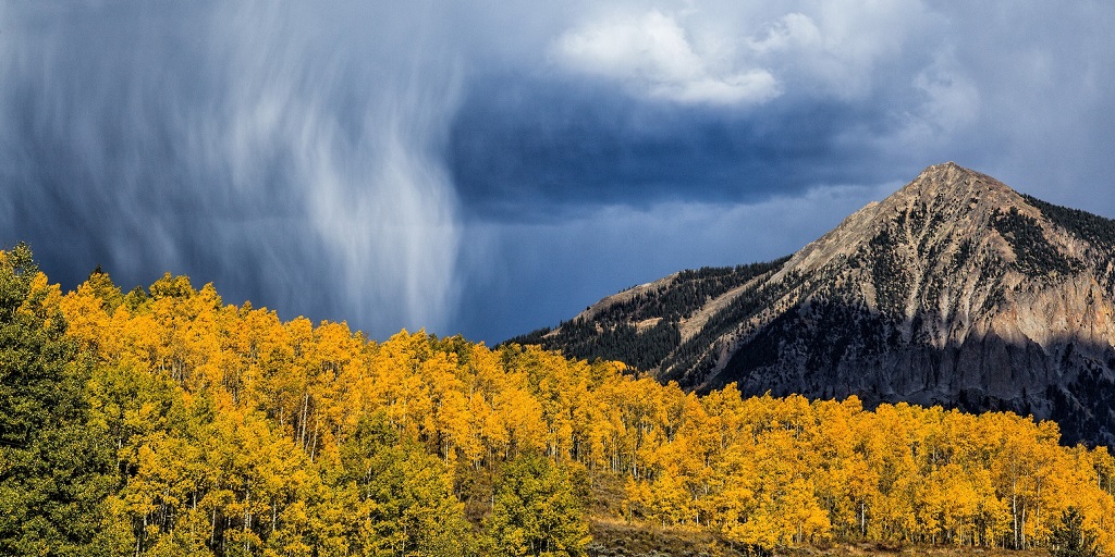 Golden autumn in the mountains, against the backdrop of clouds