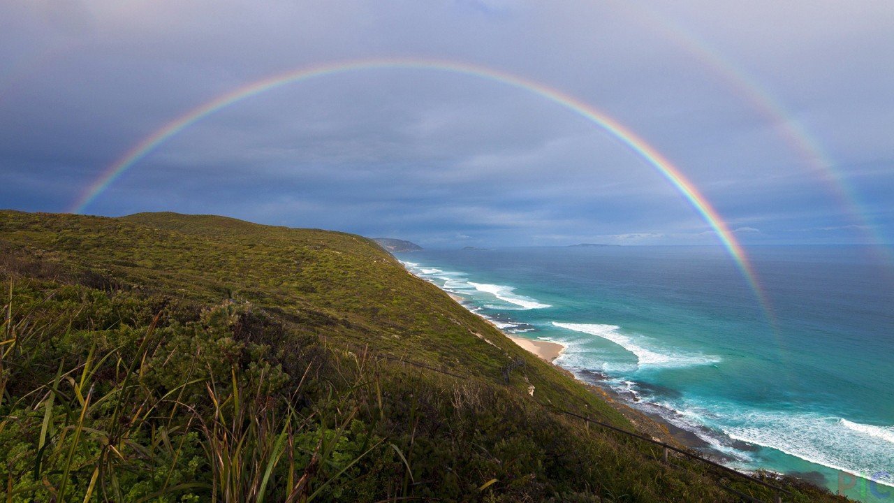 Double rainbow over the ocean shore