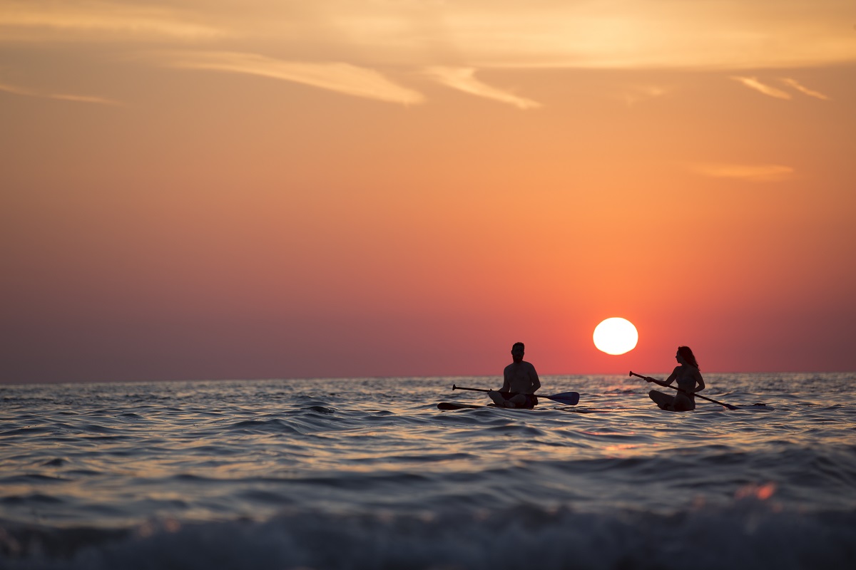 Photo of sunset on the sea, a couple in a kayak at sunset