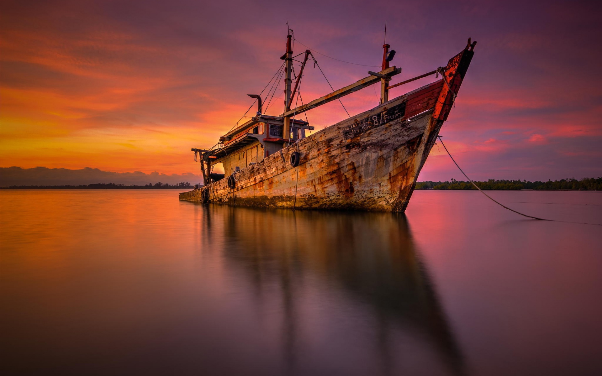 The sunken ship in the bright colors of the setting sun