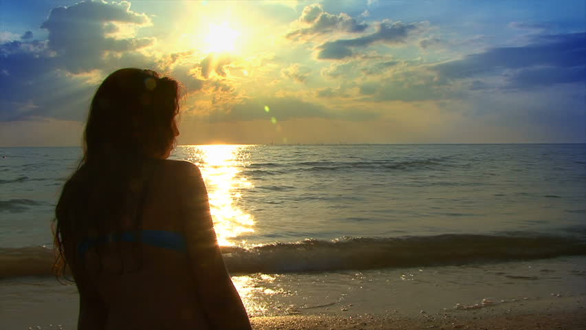 Foto av en tjej på havet vid solnedgången