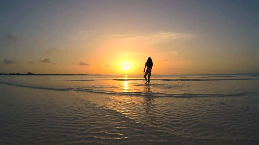 Photo of a girl on the sea at sunset
