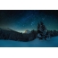 Starry sky, mountains and forest in winter