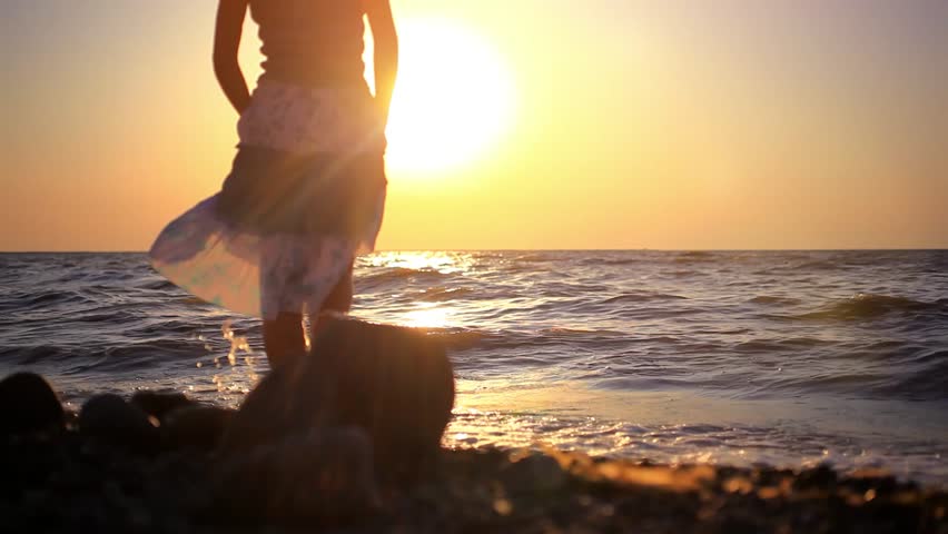 Foto van een meisje op het overzees bij zonsondergang