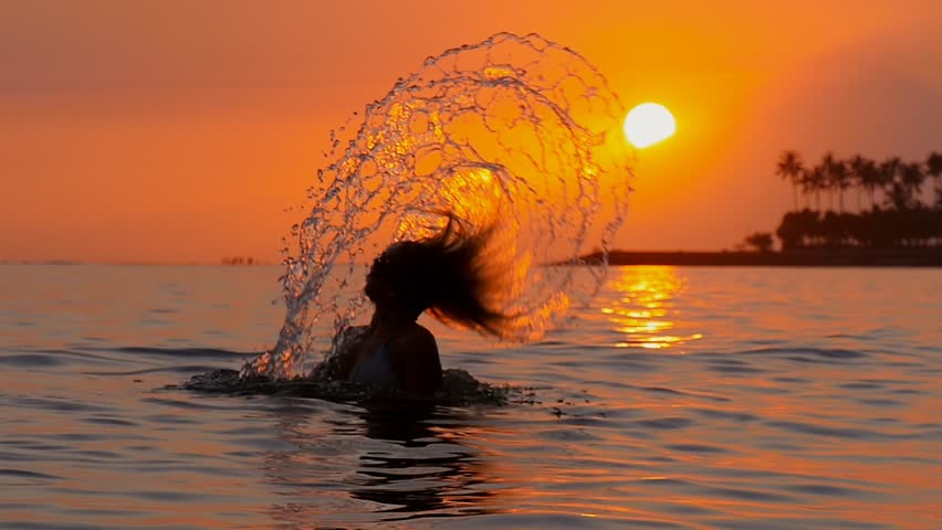 Foto de una niña en el mar al atardecer