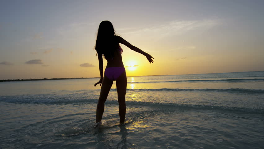 Fotografija dekle na morju ob sončnem zahodu