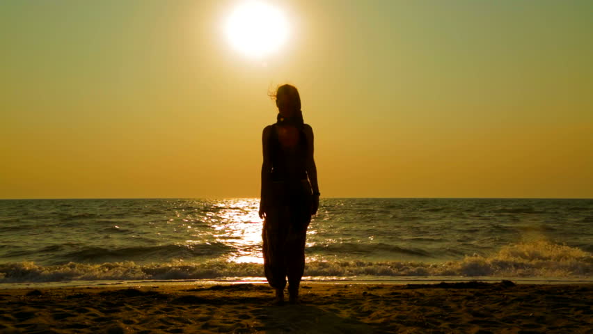 Gambar seorang gadis di laut ketika matahari terbenam