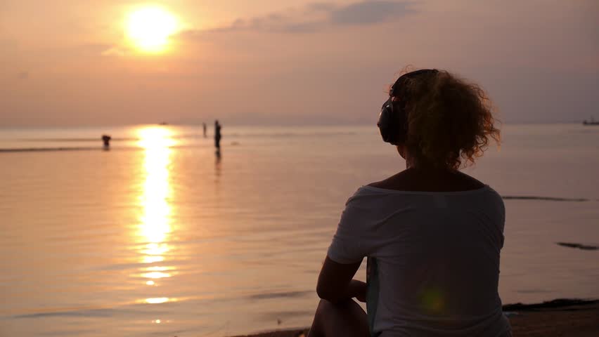 Foto tüdrukust päikeseloojangul merel