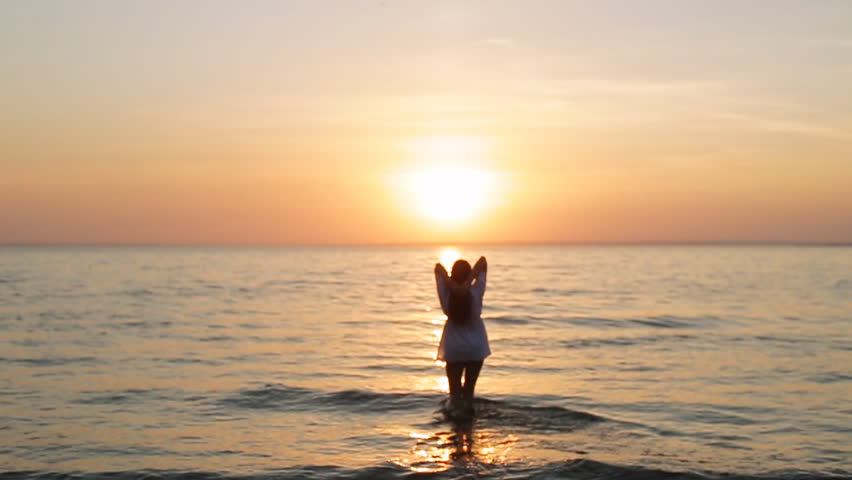 Foto tüdrukust päikeseloojangul merel