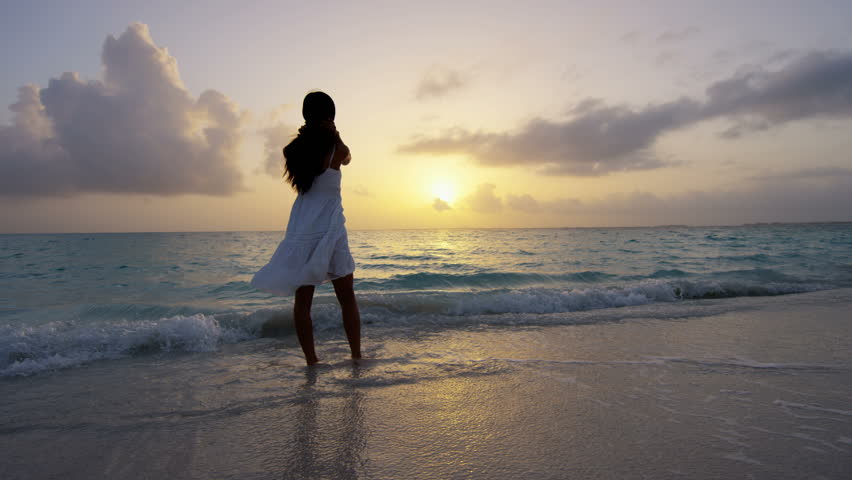 Foto de uma garota no mar ao pôr do sol