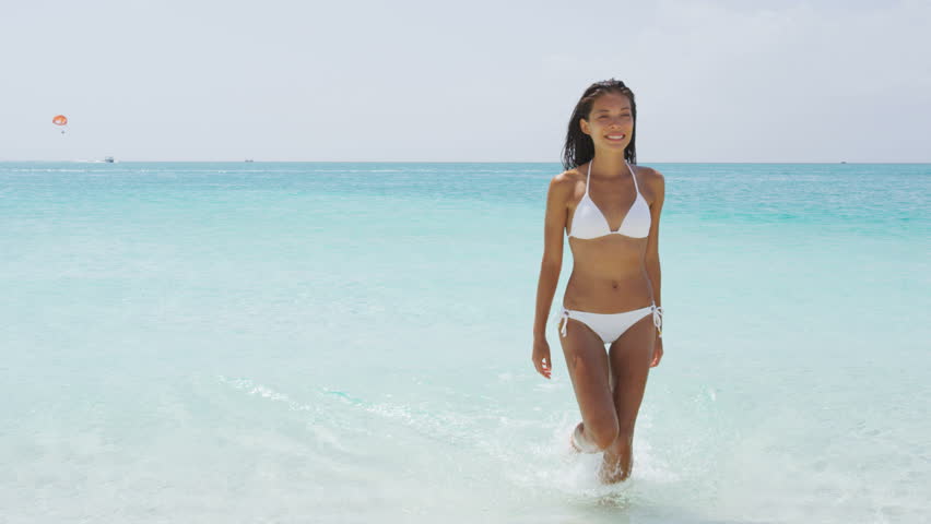 Foto de uma garota na praia em trajes de banho