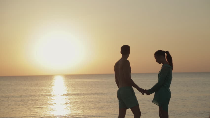 عکس یک زن و شوهر در دریا در غروب آفتاب