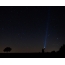 Foto: de mens schijnt een flitslicht in de sterrige hemel