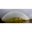 Dubbele regenboog over de berg bij het meer