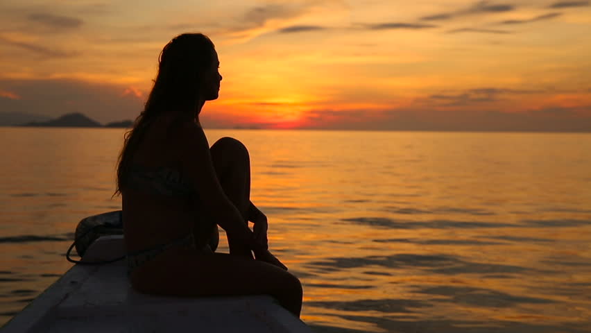 Photo of a girl on the sea at sunset