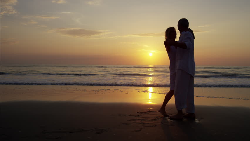 Photo of a couple on the sea at sunset